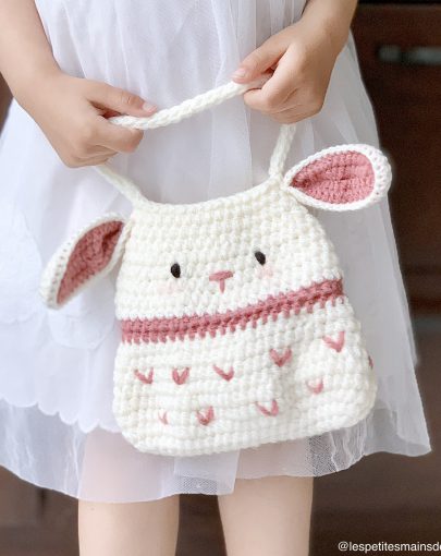 Petite fille tenant un sac en tricot